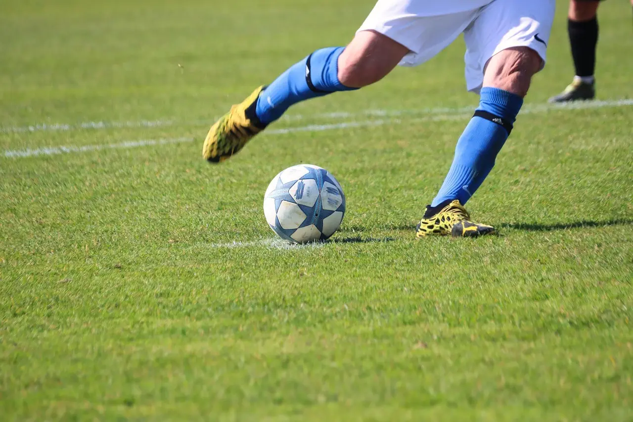 Fodboldspiller sparker til en bold